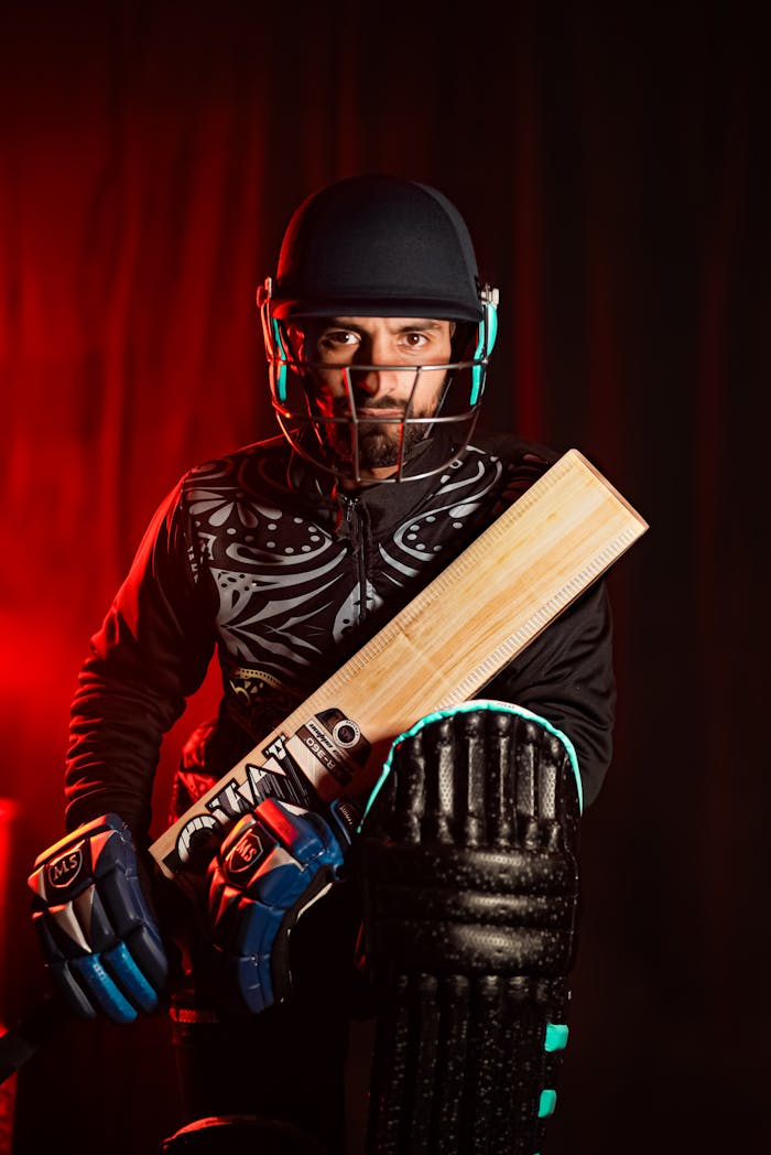 Dynamic portrait of a cricketer in full gear, holding a bat ready for action.
